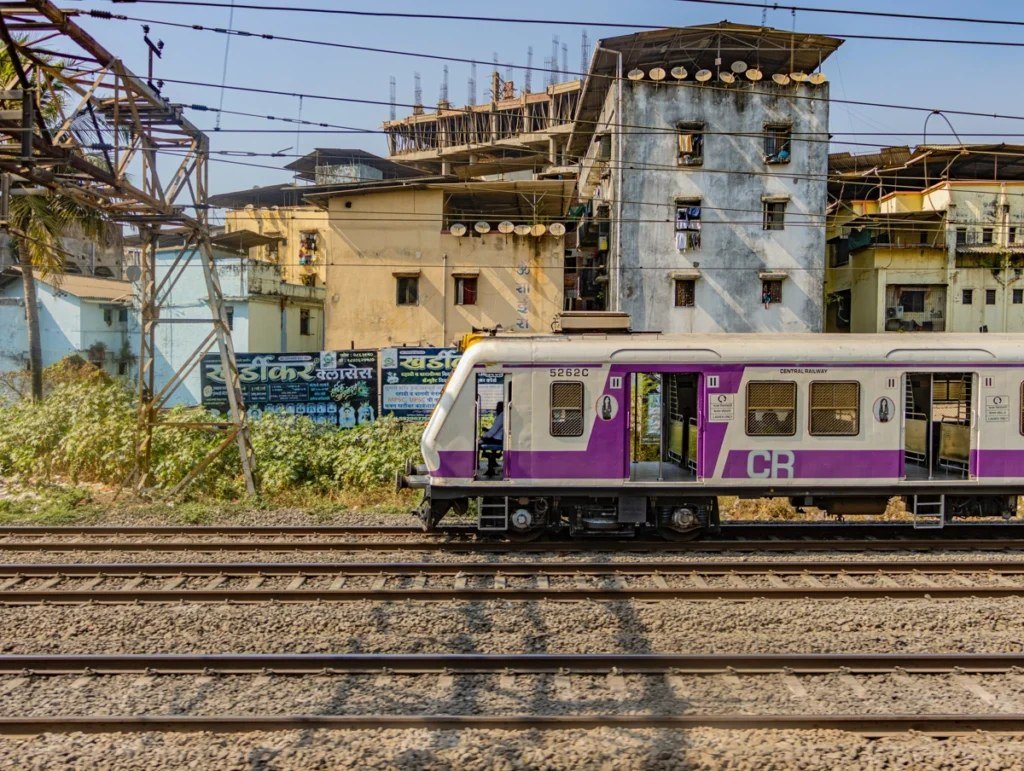 A Central Railway local train passing residential buildings